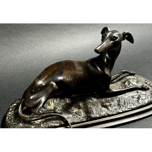 541 - A small bronze recumbent whippet, 21cm from nose to tail (base length) together  with a bronzed resi... 