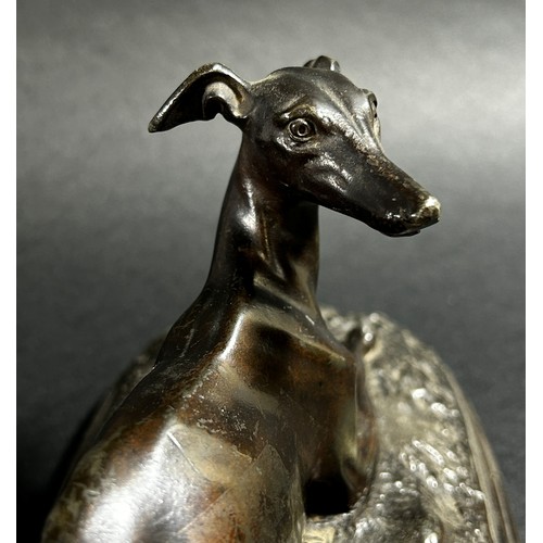 541 - A small bronze recumbent whippet, 21cm from nose to tail (base length) together  with a bronzed resi... 