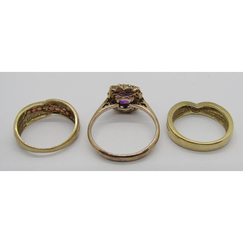 250 - Three 9ct rings; a channel set garnet and diamond crossover example, a further diamond set wishbone ... 