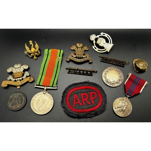 876 - A box of regimental cap badges, defence medal, ARP badges etc