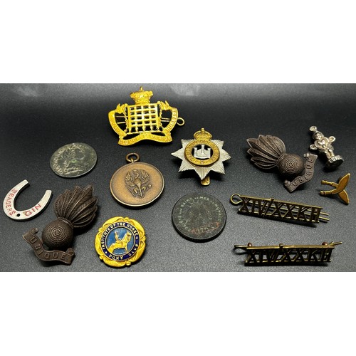 876 - A box of regimental cap badges, defence medal, ARP badges etc