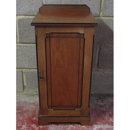 A late Victorian walnut and ebonised banded bedside cupboard enclosed by a rectangular panelled door, 84cm high x 41cm wide x 36cm deep