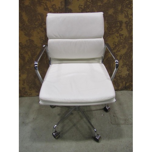 A contemporary chrome framed office chair with swivel base, upholstered in a faux white leather finish