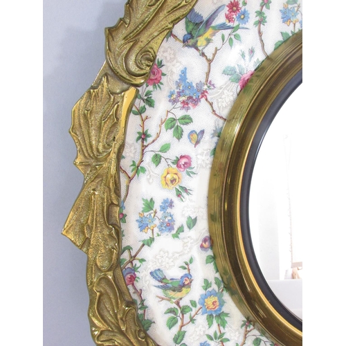 472 - An ormolu mounted convex mirror set in Burslem plate decorated with roses & birds and an outer frame... 