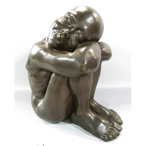 493 - A bronze effect resin study of a naked figure, sleeping on arms resting on drawn up knees, 34cm high... 