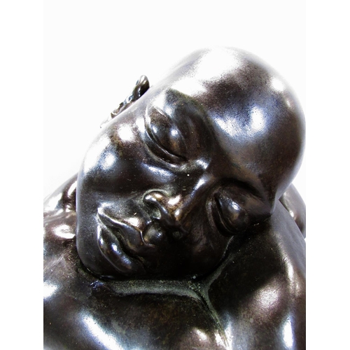 493 - A bronze effect resin study of a naked figure, sleeping on arms resting on drawn up knees, 34cm high... 