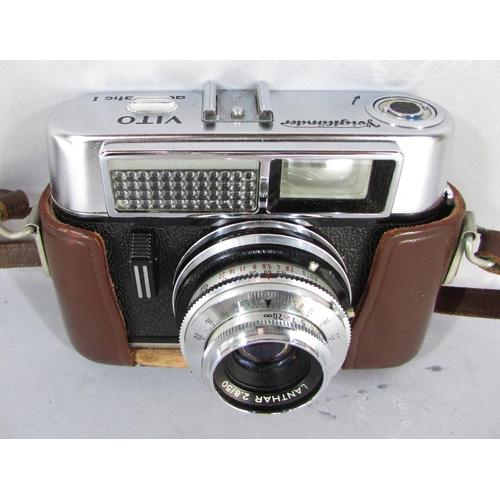 503 - A Voigtlander vintage camera, a pair of military binoculars, a pair of green rubberised water resist... 