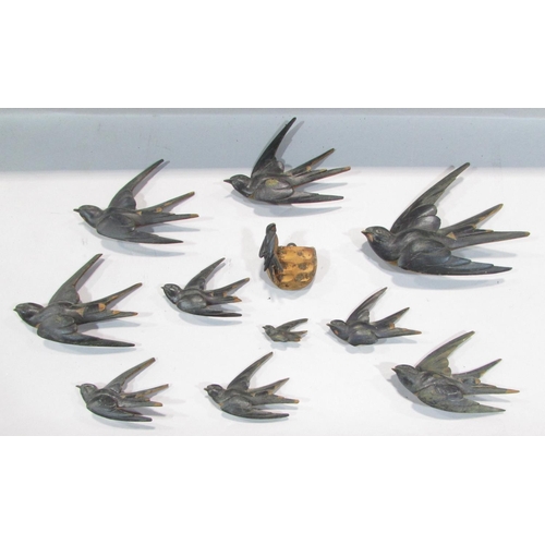 511 - Nine wooden swallows in flight, of varying sizes, with a nest and two fledglings,  possibly from a m... 