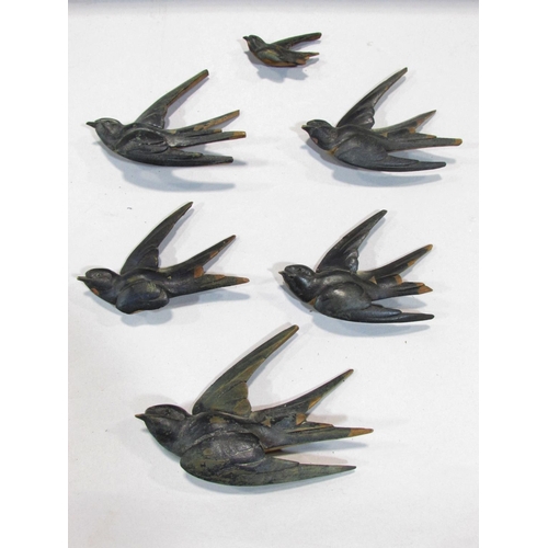 511 - Nine wooden swallows in flight, of varying sizes, with a nest and two fledglings,  possibly from a m... 