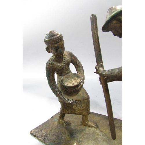 542 - A bronze study of two South East Asian Farmers toiling. 12cm high x 12cm.