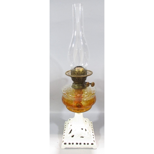 544 - A 19th century oil lamp with a painted cast iron base and amber glass font.