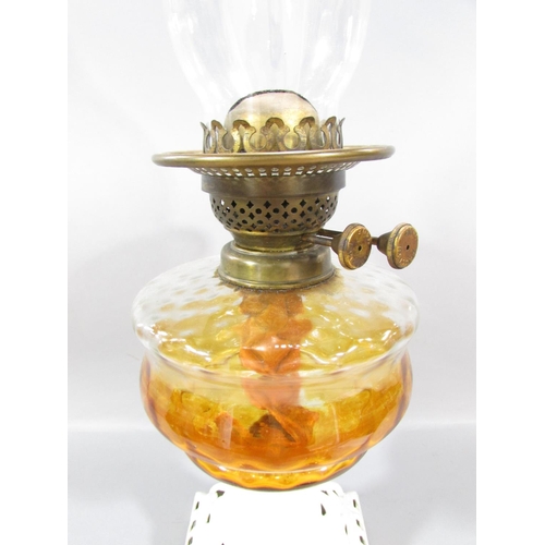 544 - A 19th century oil lamp with a painted cast iron base and amber glass font.