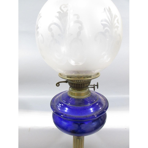 546 - A 19th century brass column oil lamp with a blue glass font and opaque decorative shade.