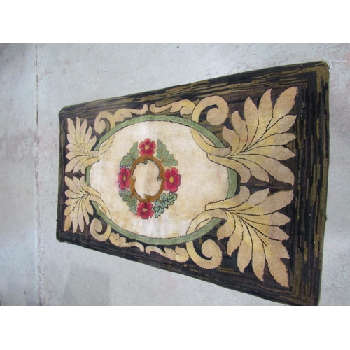 An early 20th century European decorative rug with a central floral wreath and scrolled foliate borders, 195cm x 110cm