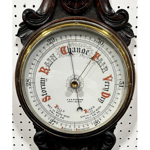 463 - An Edwardian aneroid barometer with carved oak case, porcelain dials with coloured detail by A & R R... 