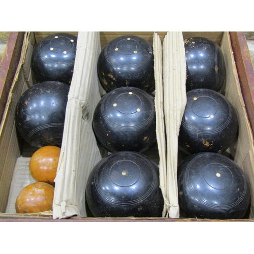 1108 - A cased set of lawn bowls, 8 large balls in ebony together with two smaller boxwood examples