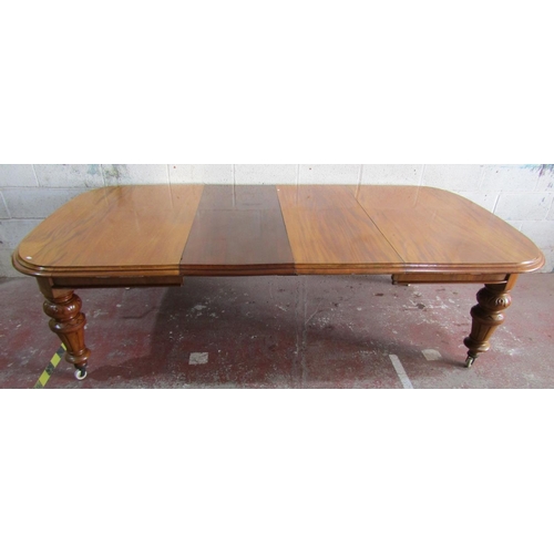 A large Victorian mahogany wind out extending dining table with moulded edge and slightly rounded ends, two additional leaves raised on turned and carved supports with white ceramic castors, 74cm high x 265cm long x 135cm wide