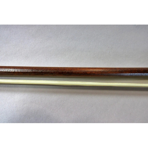 551 - A violin bow stamped Pecatte above both sides of the Frog with a mother-of-pearl eye, 75 cm long