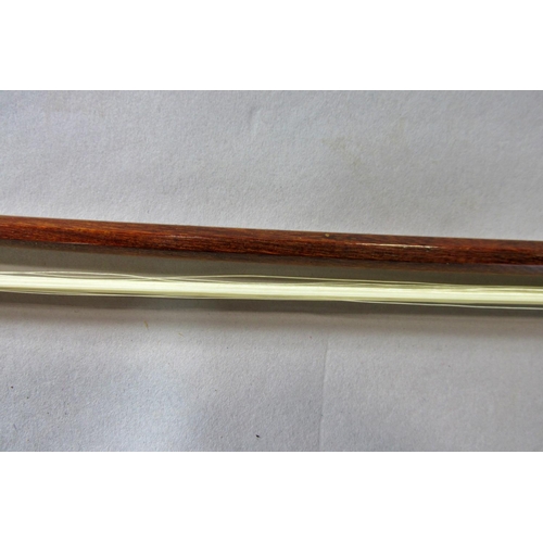 551 - A violin bow stamped Pecatte above both sides of the Frog with a mother-of-pearl eye, 75 cm long