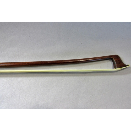 551 - A violin bow stamped Pecatte above both sides of the Frog with a mother-of-pearl eye, 75 cm long