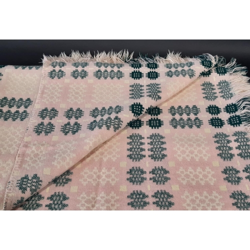 882 - A traditional woollen Welsh blanket of reversible double weave in pink, green, white and cream colou... 