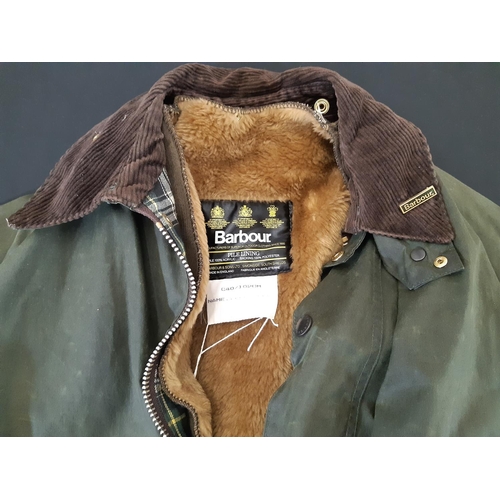 883 - A Barbour 'Beaufort' waxed jacket  in green with 2-way front zip, brown corduroy collar and numerous... 