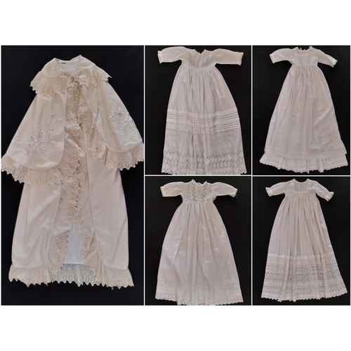 884 - Five early 20th century baby garments including a cream woollen carry shawl with embroidered yoke an... 