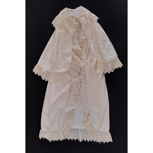 884 - Five early 20th century baby garments including a cream woollen carry shawl with embroidered yoke an... 