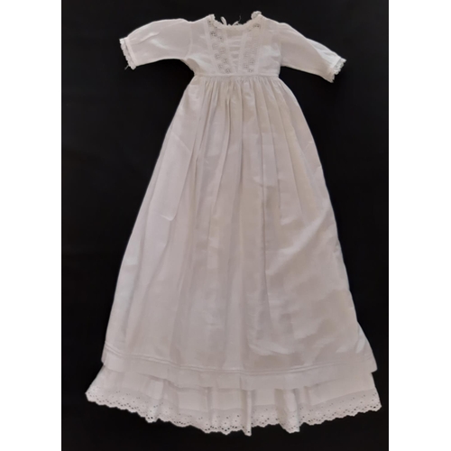 884 - Five early 20th century baby garments including a cream woollen carry shawl with embroidered yoke an... 