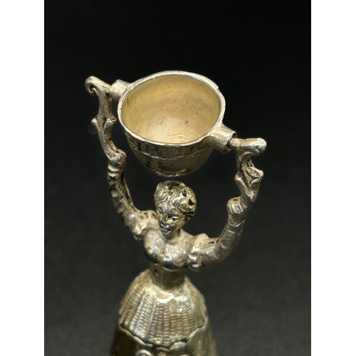 168 - A silver table bell in the form of a dancing woman, with English hallmarks, together with a miniatur... 