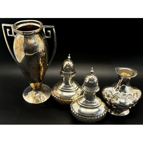 182 - A group of silver pieces to include a pair of salt and pepper shakers, a silver trophy, a posy vase,... 