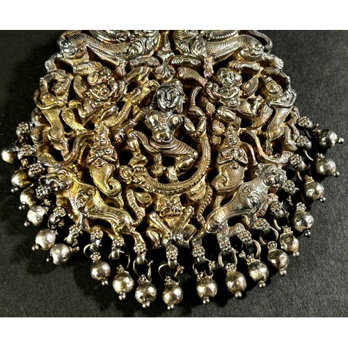 203 - A silver metal ornate Indian head dress ornament with a central dancer surrounded by figures and mys... 