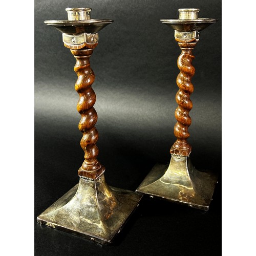 214 - A pair of early 20th century English Arts & Crafts oak barley twist candlesticks with silver sconces... 