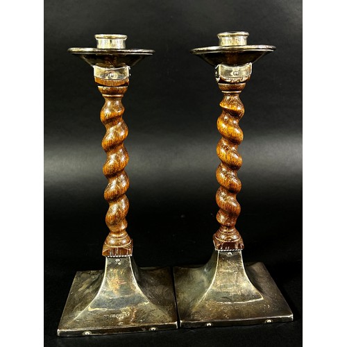 214 - A pair of early 20th century English Arts & Crafts oak barley twist candlesticks with silver sconces... 