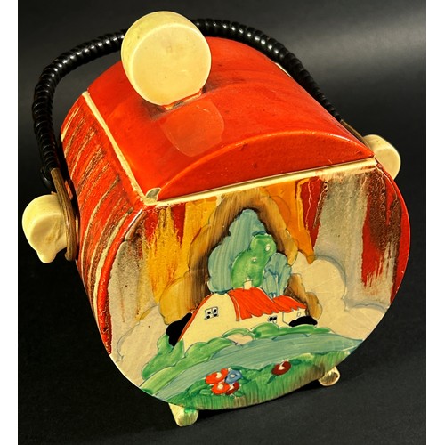 64 - A Clarice Cliff Bizarre biscuit barrel and cover with wicker handle, red roof cottage pattern