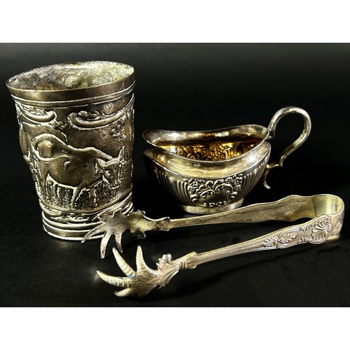 190 - A small silver cream jug, a silver bird claw sugar tong and a Dutch? beaker with a dairy farm scene,... 