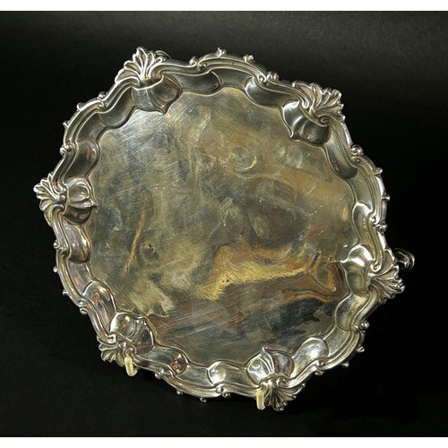 184 - A small George II silver salver with ogee scroll and shell rim, raised on three pad feet, London 175... 