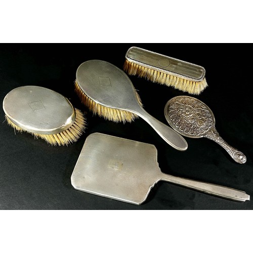 216 - A mixed collection of  silver backed hair and clothes brushes and two silver backed hand mirrors