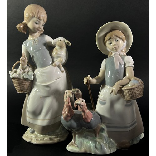 105 - Three Lladro figures, one of a girl shepherding Turkey's, another holding a Lamb, a third with a bou... 