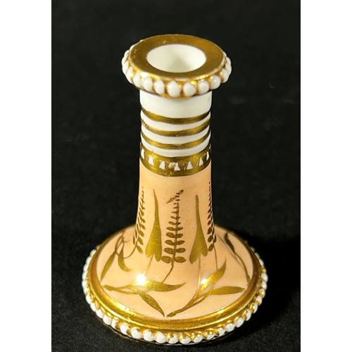 408 - A miniature Spode taper stick with beaded borders on a pale salmon ground, overlaid with gold detail... 