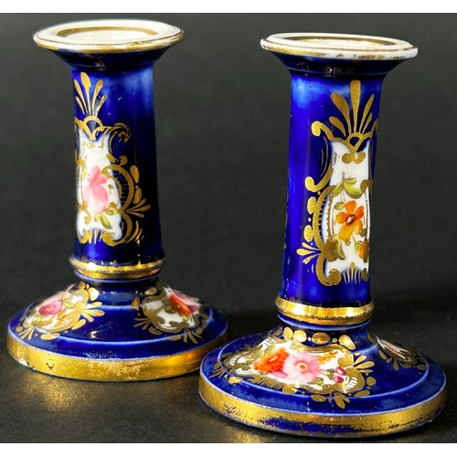 410 - A miniature pair of Coalport candlesticks decorated with hand painted sprays of flowers and gilding ... 