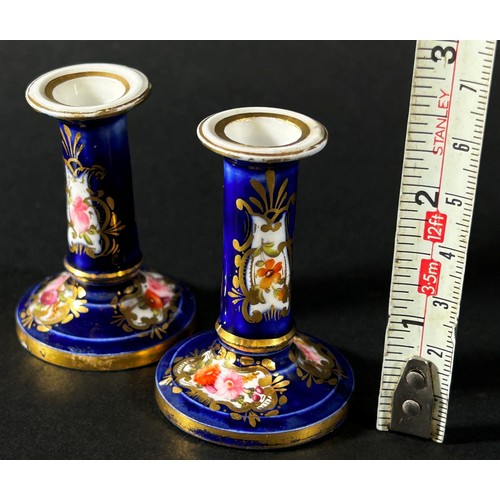 410 - A miniature pair of Coalport candlesticks decorated with hand painted sprays of flowers and gilding ... 