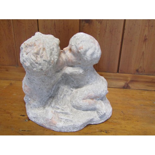 1010 - A faux weathered terracotta garden ornament in the form of kissing cherubs, 26 cm high
