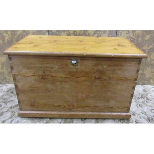 1063 - A stripped pine blanket box with hinged lid and brass drop side carrying handles, 56 cm high x 91 cm... 