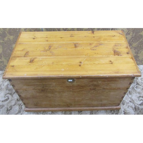 1063 - A stripped pine blanket box with hinged lid and brass drop side carrying handles, 56 cm high x 91 cm... 