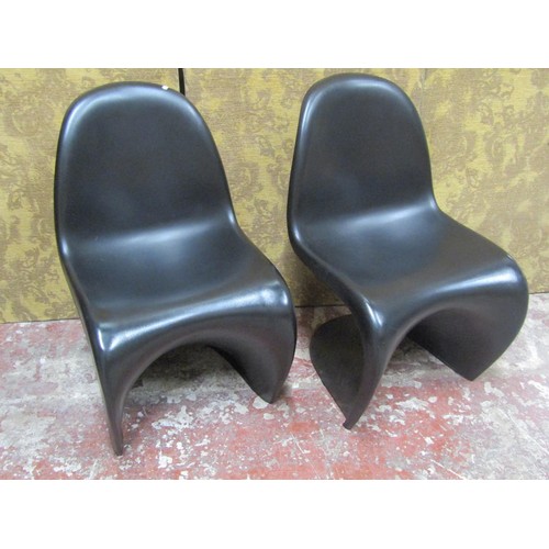 1082 - A pair of contemporary moulded plastic cantilever chairs in a black colourway in stacking format Pan... 