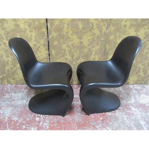 1082 - A pair of contemporary moulded plastic cantilever chairs in a black colourway in stacking format Pan... 