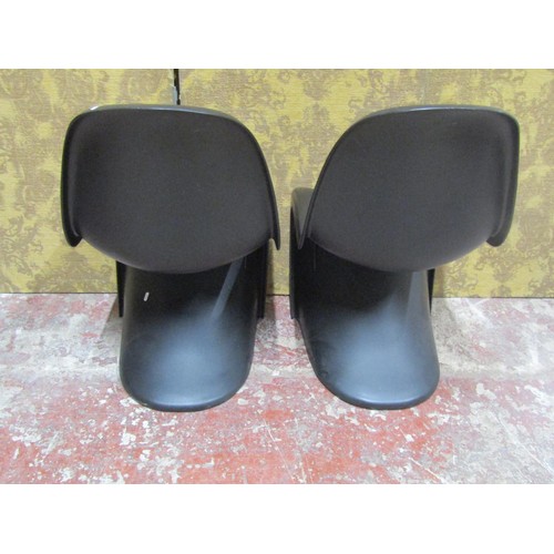 1082 - A pair of contemporary moulded plastic cantilever chairs in a black colourway in stacking format Pan... 