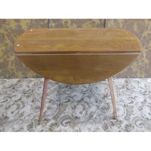 1093 - An Ercol elm and beechwood oval drop leaf dining table raised on splayed square tapered supports, 72... 