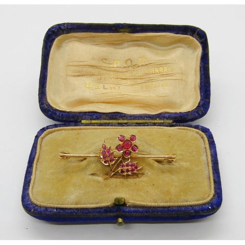 314 - Yellow metal bar brooch set with a floral cluster of rubies, 4.2cm W approx, 3.1g, contained in a po... 